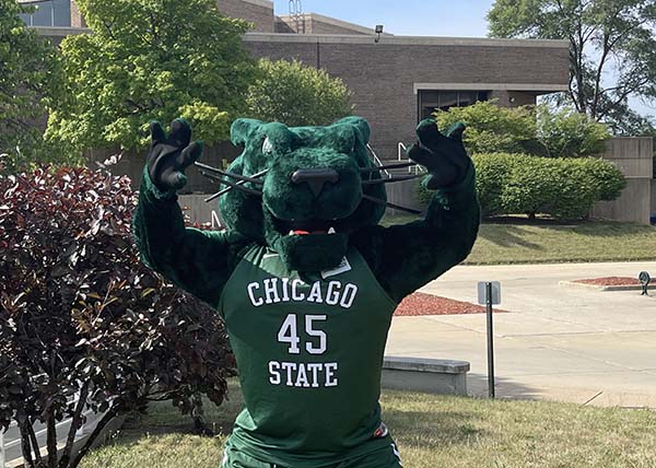 Chicago State University mascot poses with his paws up. The mascot's fur is dark green and he's wearing a Chicago State jersey and shorts with the number 45.