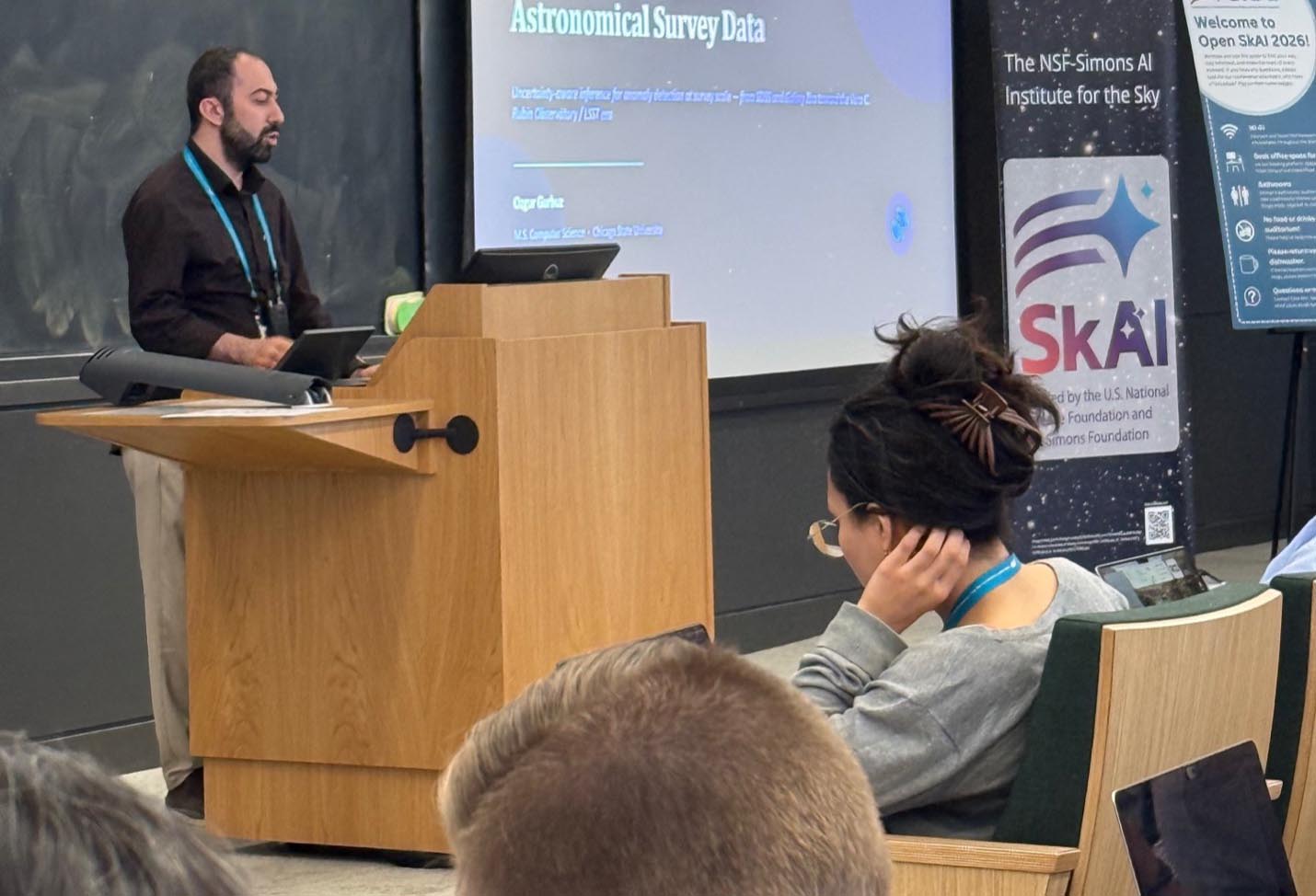 CSU student Ozgur Gurbuz speaks behind a podium while presenting a slide titled astronomical survey data.