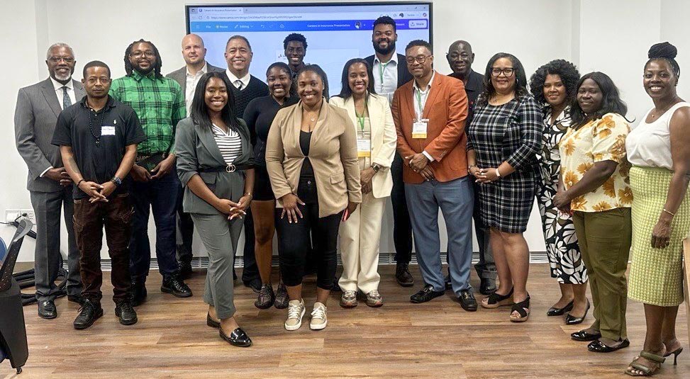 A large group of students and professionals posing together in a classroom setting for a photo after a Chubb/CSU event.