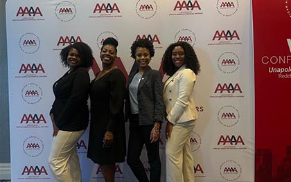 our women posing together in front of the AAAA conference backdrop